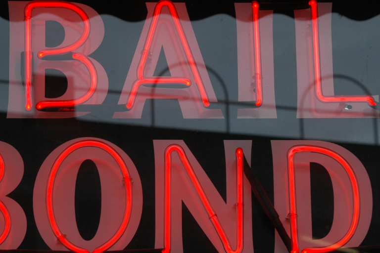 Image red neon commercial sign displaying the words bail bonds, against a black background.
