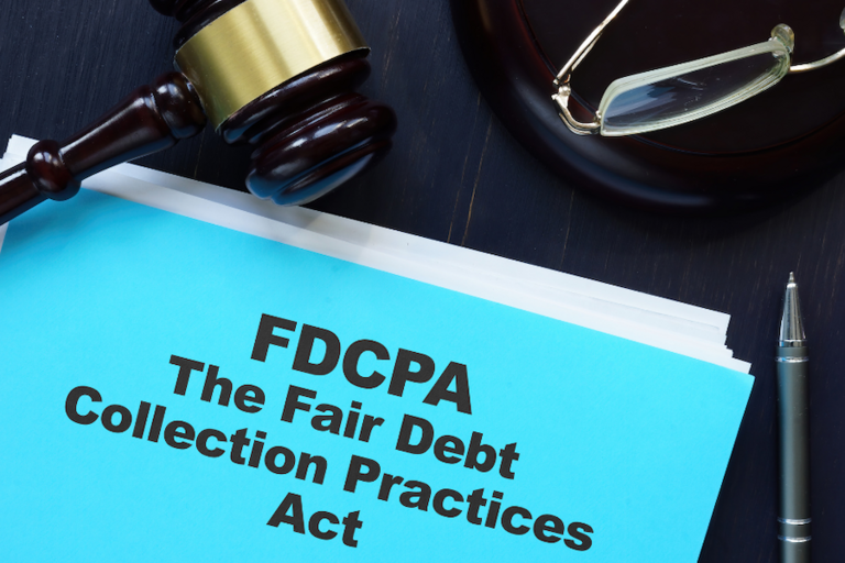 Image of gavel, eyeglasses, pen, and stack of blue papers reading "FDCPA - Fair Debt Collection Practices Act"