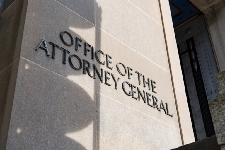 Metal lettering displaying "Office of the Attorney General" on a stone wall.